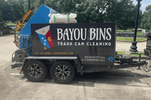Close-up of Bayou Bins trailer showing company branding and cleaning setup
