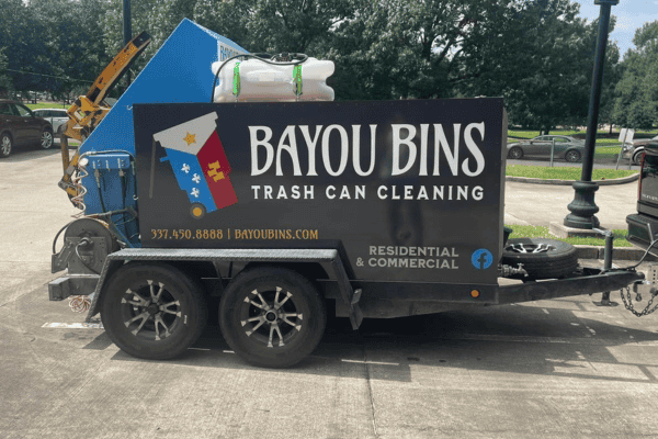 Close-up of Bayou Bins trailer showing company branding and cleaning setup