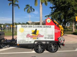 Trash can cleaning service truck parked outdoors with palm trees in the background, featuring company branding for a professional eco-friendly trash bin cleaning service.